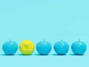 quatre pommes bleues et une pomme jaune qui illustre une idée ou un concept innovant
