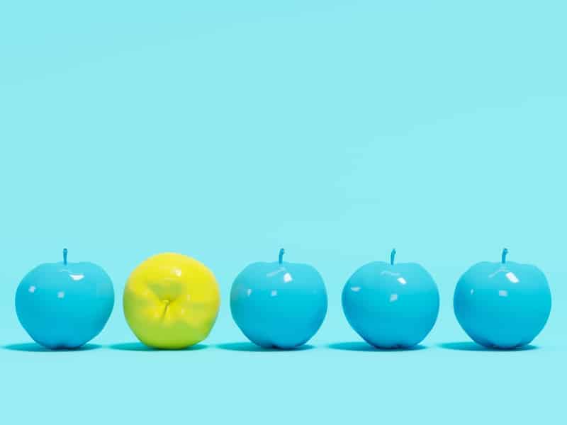 quatre pommes bleues et une pomme jaune qui illustre une idée ou un concept innovant