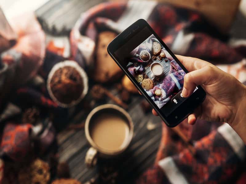 vue du dessus d'un iphone prenant une photo instagram d'un café et de nourriture
