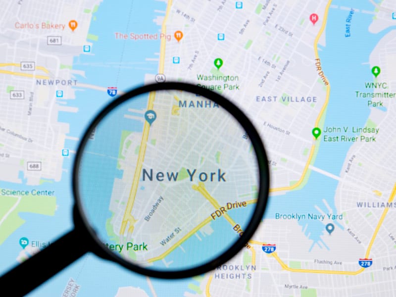 loupe grossissante pointant sur la ville de new york sur une carte google maps