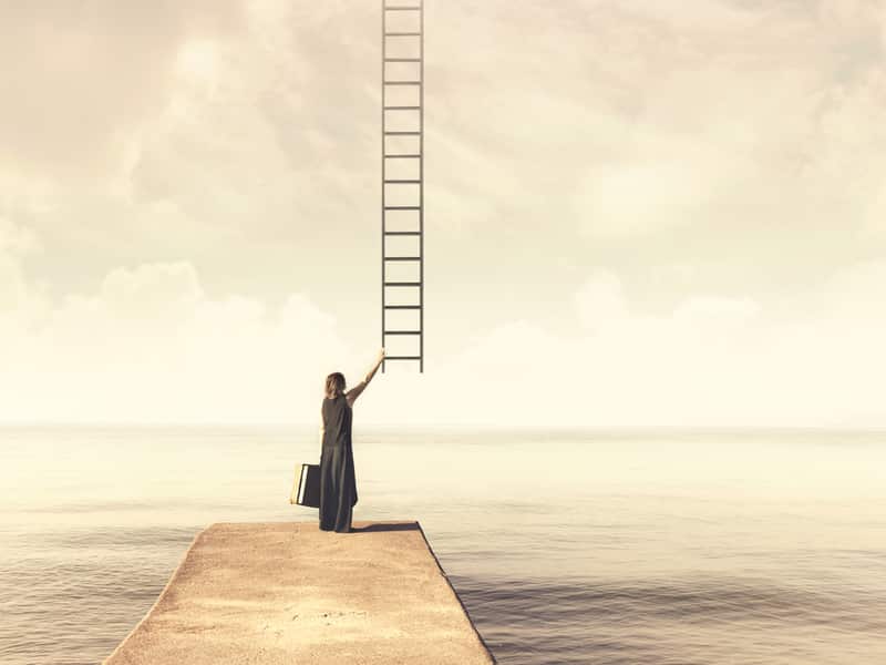 femme sur le point de grimper à une échelle qui monte dans le ciel