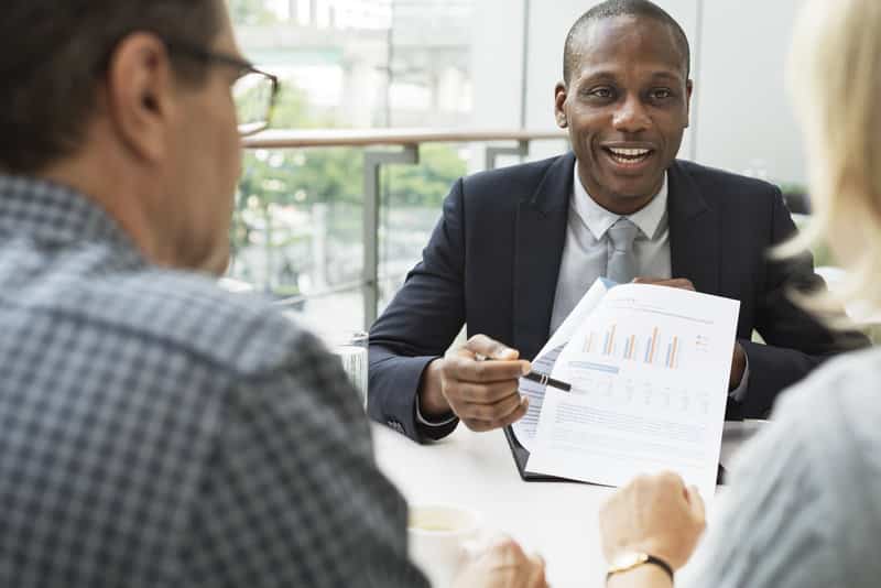 A banker shows rates to a pair of small business owners