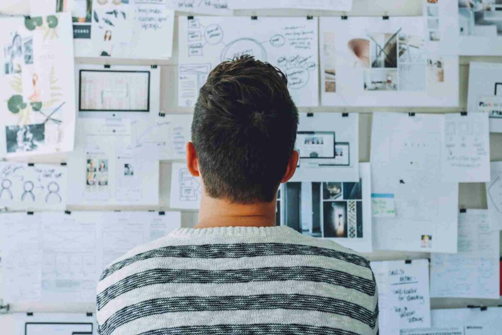 Man looking at a wall of keyword research ideas and suggestions