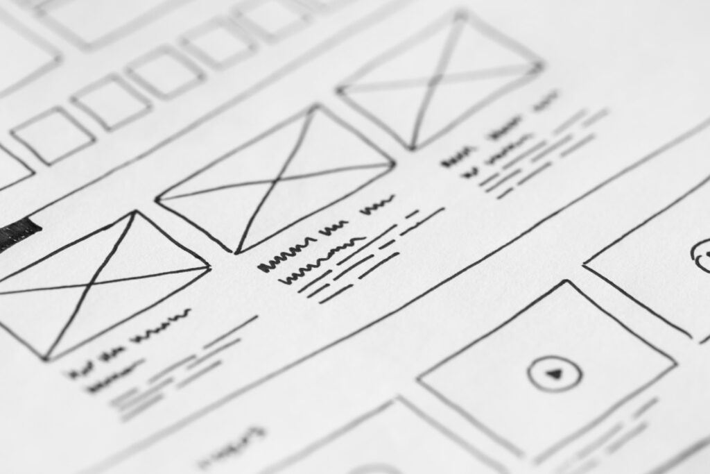 A mockup of a website including notes to make it better drawn out in pen on paper.