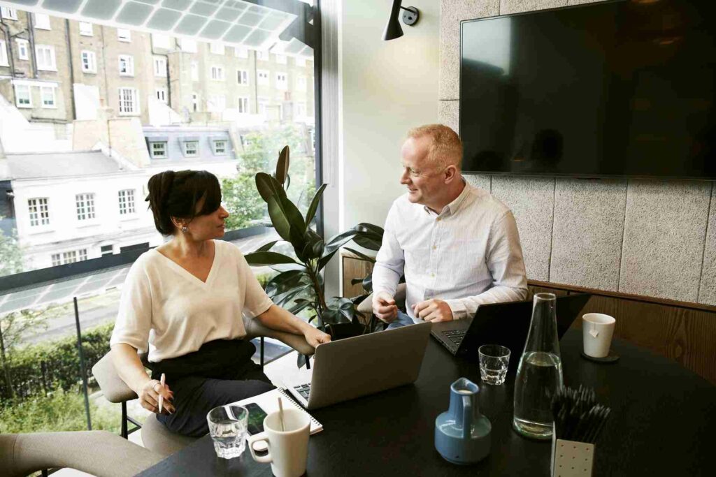 A man and a woman in an office discussing their business.