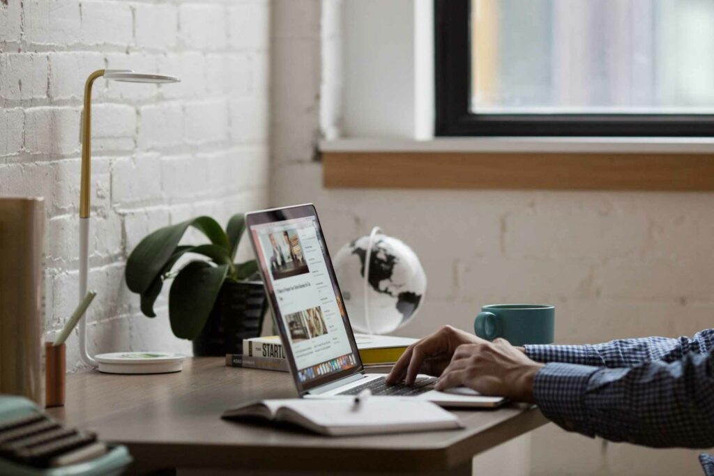 A man sitting at a desk sharing his new website across the internet