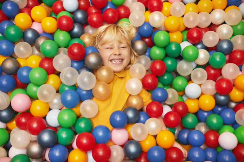 boy in pool with balls