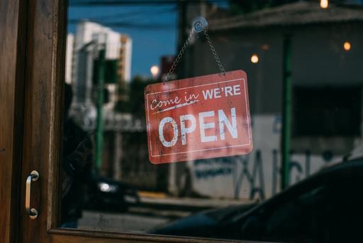 A come in, we're open sign on a storefront