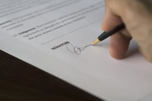 A person adding their signature to a document
