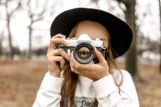 A woman using a camera in a field