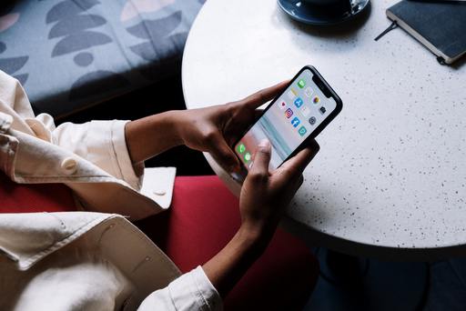 Person holding a smart phone at a table