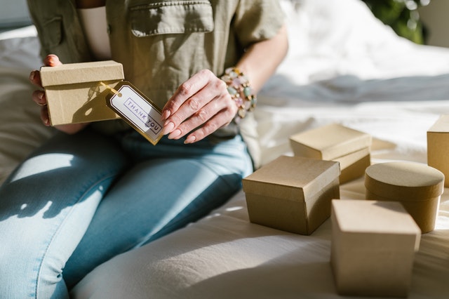 a woman adding thank you labels to her small business orders