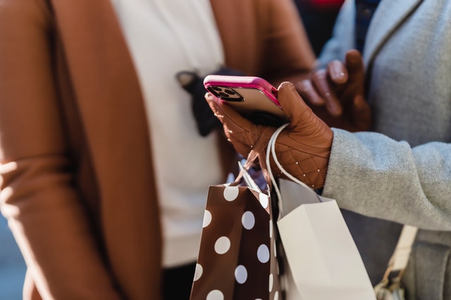 Two women shopping together on a smartphone