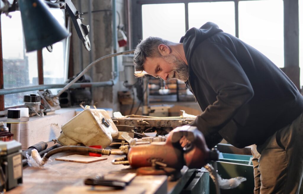 Mechanic working in a garage, validating his idea before he commits to this small business full time.
