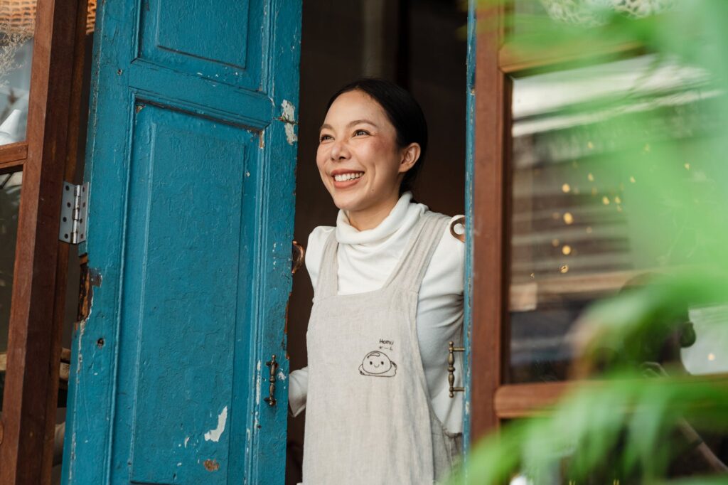 Small business owner outside of her coffee shop smiling